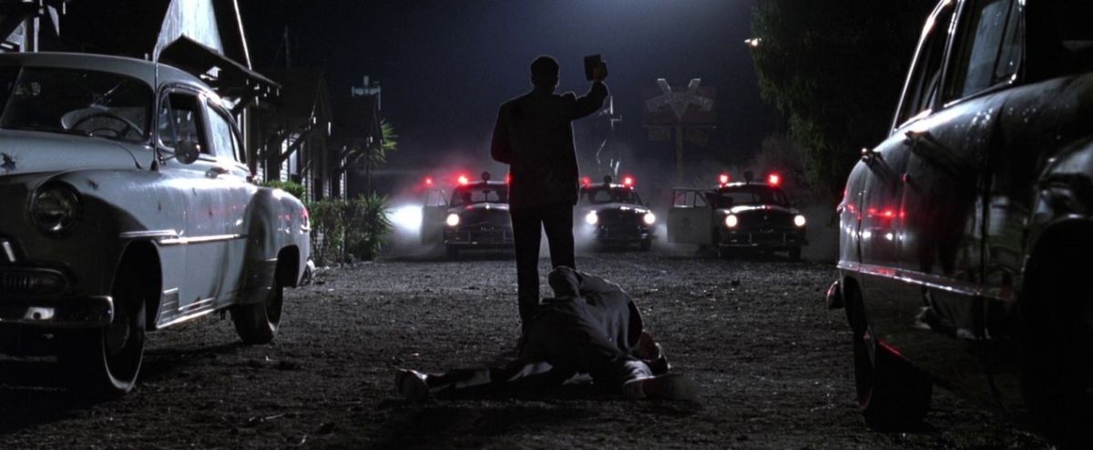 Materializing in dusty silhouette, Exley flashes his badge to halt oncoming officers after the film's climactic shootout. This confrontation was one of many sequences in which Spinotti used darkness to demarcate the visual crux of the scene.