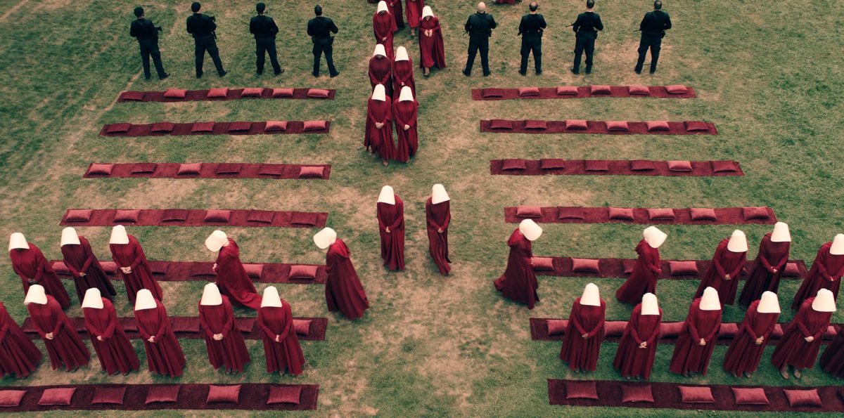 A crane-mounted camera captures the handmaids in formation.