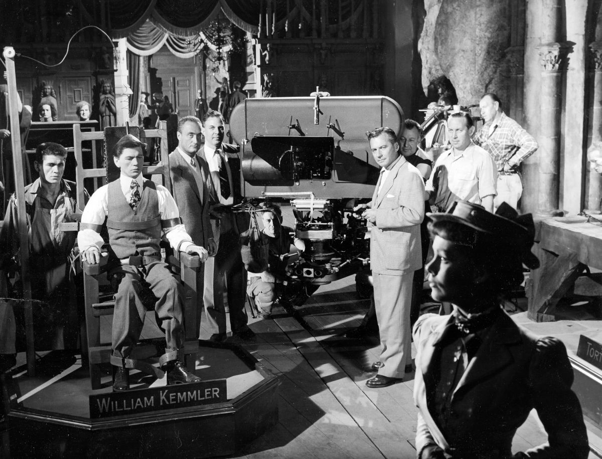 Actors Charles Bronson (far left) and Phyllis Kirk (foreground) are positioned for a take during the production of House of Wax (1953), one of the most popular of the stereoscopic films made during the 3D craze of the 1950s. Warner Bros. unit photographer Jack Woods snapped this shot as the Natural Vision camera unit — designed by Milton Gunzberg — was about to roll. House of Wax was screened using dual interlocked 35mm projection with polarized glasses. The film was re-released in the late 1970s in both single-strip 35mm Stereovision 3D and Stereovision’s pioneering 70mm 3D process. Ironically, House of Wax director André De Toth (left of camera, in white vest, next to studio exec Jack M. Warner) was blind in one eye and unable to actually see his film’s 3D effects. To that end, he relied on ASC cinematographers Bert Glennon, Peverell Marley and Robert Burks (right, in front of the camera), operator Howard Schwartz (far right, in white shirt), and 3D consultant Lothrop B. Worth (crouching under camera), both of whom later became Society members.