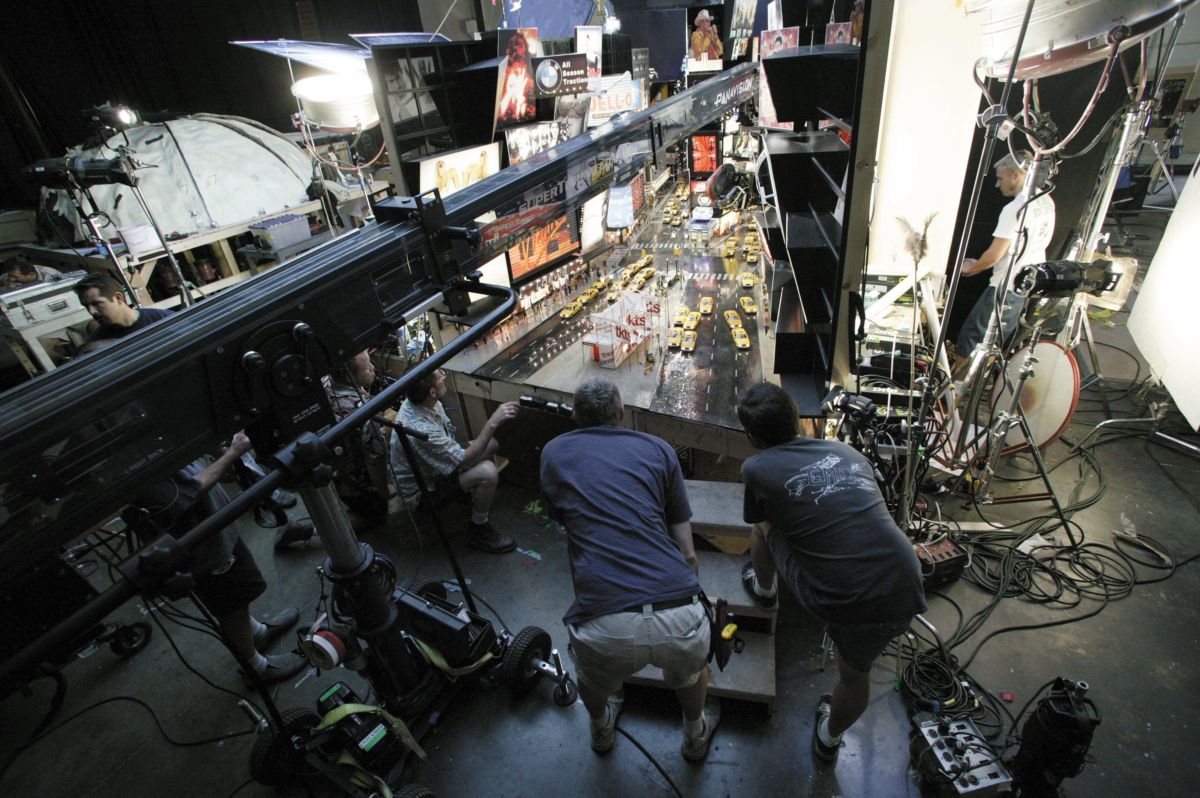 The filmmakers eyeball a traffic jam of yellow taxis on a scale model of New York’s Times Square as a Super Technocrane-mounted PanArri 435 captures the action. All of the elements in this complex frame had to be “animated” live, manually on the set. Notes Stone, “We didn’t want to ruin the magic of the film by using digital effects. If we’d started using CGI, then the things that we did do in camera would have become suspect. Besides, because we could blow up the puppets, there was no reason to create visual-effects shots.”