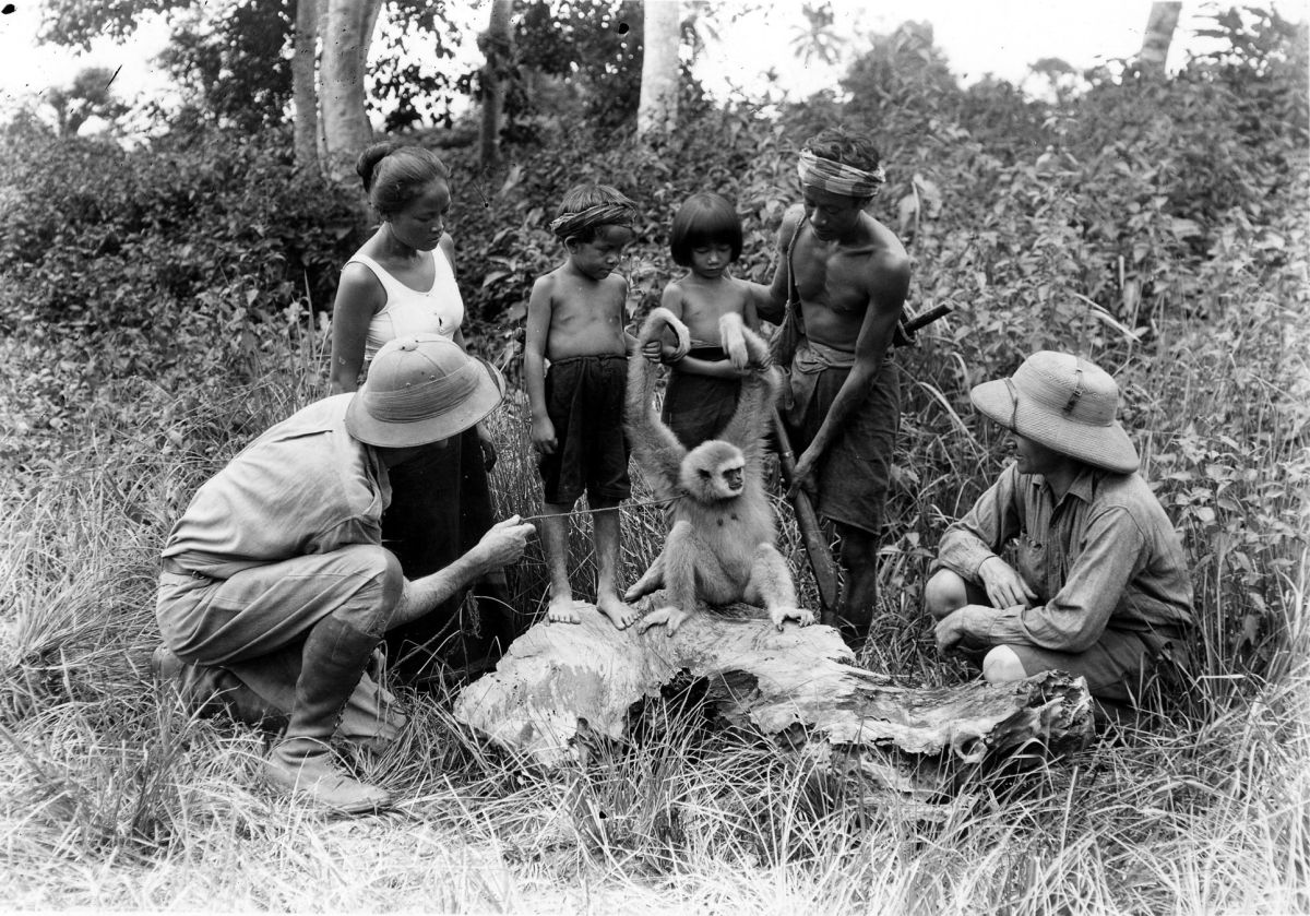 Cooper and Schoedsack, with local people in the wilds of Laos, examine a monkey while filming the docu-drama Chang: A Drama of the Wilderness (1927). Schoedsack served as cinematographer on the project.