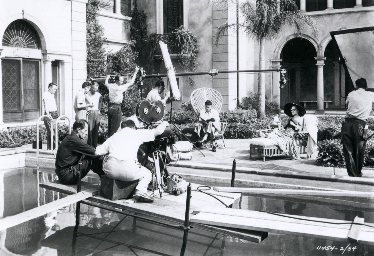 A Hollywood mansion and swimming pool was used instead of a set on the studio lot. Note reflectors employed instead of studio lamps to supply fill light on actress Gloria Swanson.